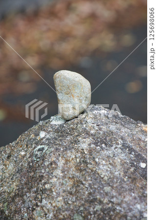 大きな岩にバランスよく立てられた小さな小石 125698066