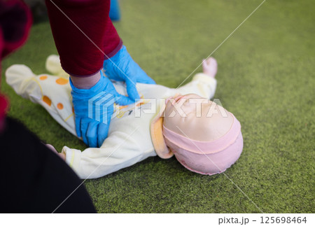 CPR training on an infant training manikin 125698464