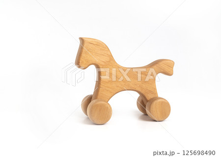Toy - handmade wooden horse on wheels isolated on white background Toy - handmade wooden horse on wheels isolated on white background 125698490