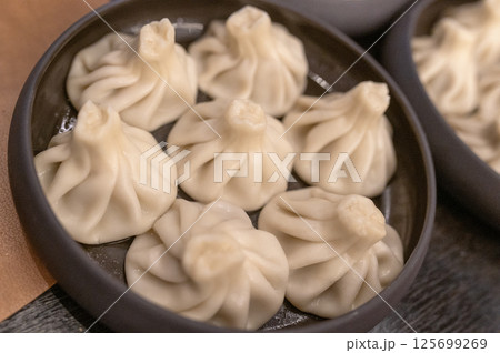 Steamed khinkali dumplings served on a black plate, georgian cuisine Steamed khinkali dumplings served on a black plate, georgian cuisine 125699269