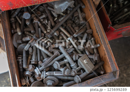 Mechanic tools, nuts and bolts filling a drawer in a workshop Mechanic tools, nuts and bolts filling a drawer in a workshop 125699289