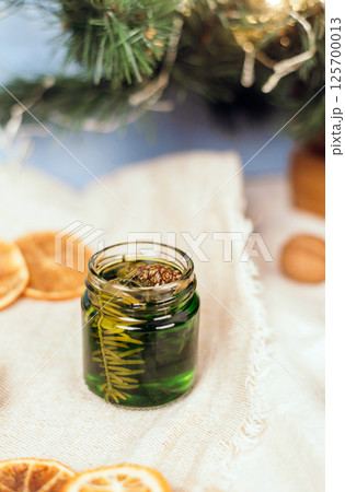 Green honey with pine needles in a glass jar. Glass jar with honey on a christmas atmosphere background. National Recipes. jam 125700013