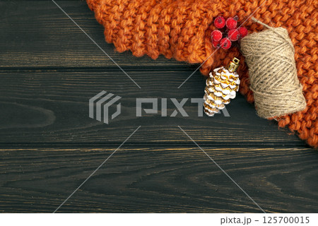 Christmas dark wood background with decorations: plaid, cone, berry and twine thread with copy space. Greeting card Christmas dark wood background with decorations: plaid, cone, berry and twine thread with copy space. Greeting card 125700015