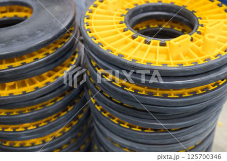 Stack of yellow and black industrial plastic parts forming a column 125700346