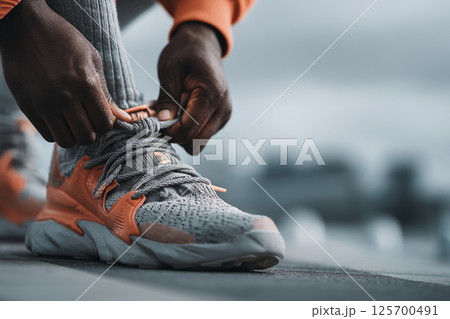Runner Tying Shoelaces on Track Before Workout 125700491