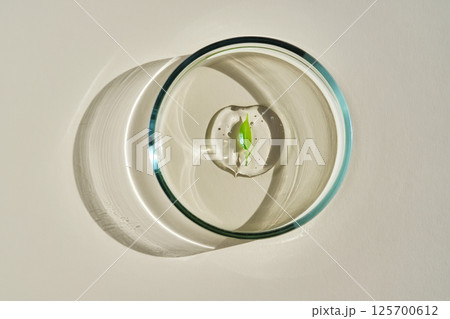 A delicious drop of serum with a leaf in a petri dish. A delicious drop of serum with a leaf in a petri dish. 125700612