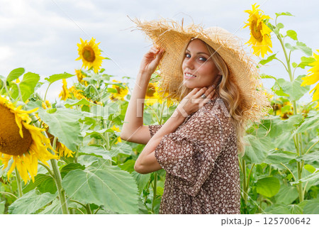Portrait of a pretty girl in a field of sunflowers. 125700642