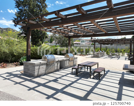 Covered gathering area in city park with green wood picnic tables Covered gathering area in city park with green wood picnic tables 125700740