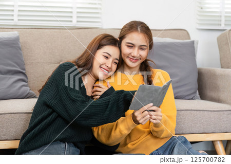 Wellness and joy: Women celebrating travel plans with a tablet and laughter 125700782