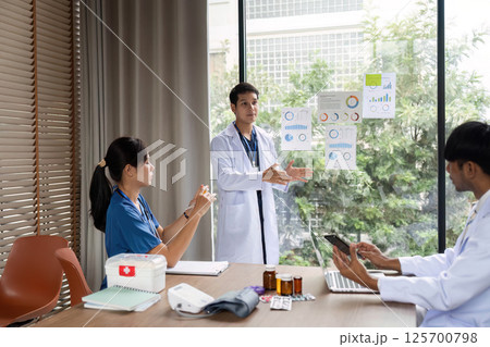 Doctor discussing medical data and treatment plans with colleagues Doctor discussing medical data and treatment plans with colleagues 125700798