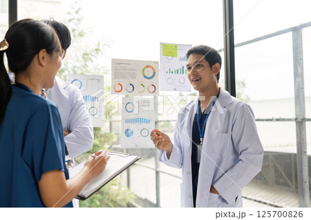 Doctors collaborating on healthcare strategies with data visuals Doctors collaborating on healthcare strategies with data visuals 125700826