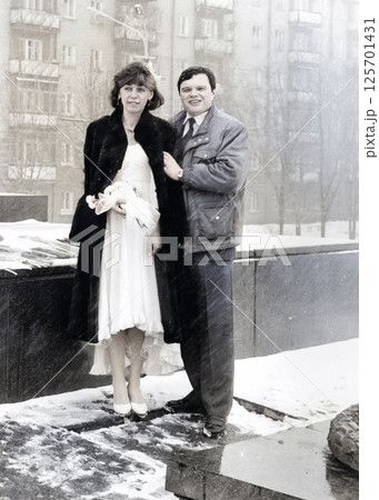 Vintage portrait of the bride and groom in the snowfall in the city. Retro photo 1993. 125701431