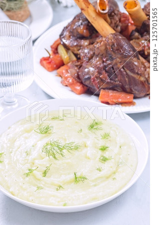 Horseradish and fennel puree or mashed potatoes with braised lamb shanks in background, vertical Horseradish and fennel puree or mashed potatoes with braised lamb shanks in background, vertical 125701565