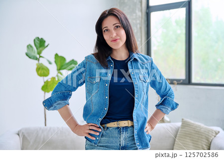 Portrait of beautiful young smiling woman in home interior 125702586