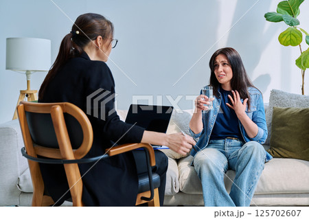 Young woman patient at mental therapy session, talking with psychologist Young woman patient at mental therapy session, talking with psychologist 125702607