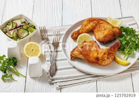 roast chicken legs with crispy skin on a plate 125702919