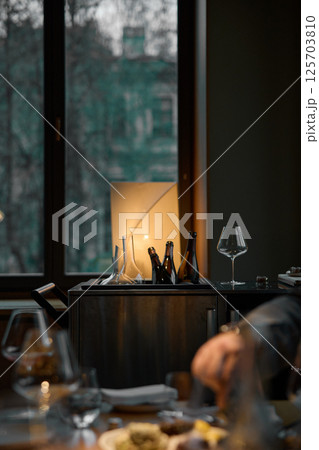 Several bottles of champagne are cooled in a niche with ice in the restaurant, local lighting, wine cabinet, decanters for sparkling wine 125703810