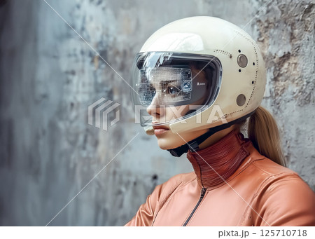 ヘッドマウントディスプレイのついたバイク用ヘルメットを被った若い女性のイメージ素材 125710718