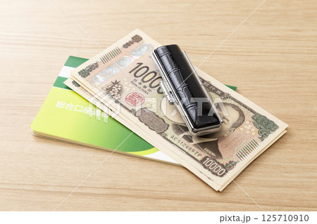 通帳と印鑑と現金 通帳と印鑑と現金 125710910