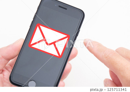 スマートフォンのメールをチェックする人の手元 スマートフォンのメールをチェックする人の手元 125711341