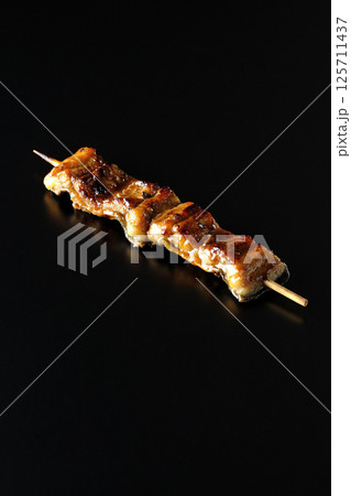 鰻の串焼きを黒背景で撮影 125711437