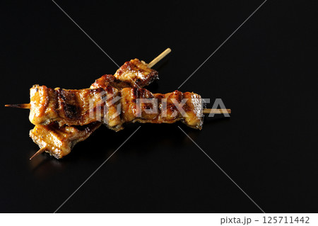 鰻の串焼きを黒背景で撮影 125711442