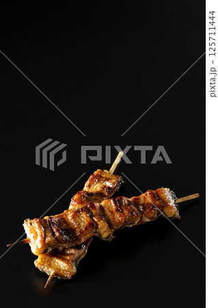 鰻の串焼きを黒背景で撮影 125711444