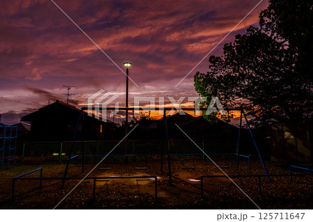 雨上がりの夕空に現れた見事な夕焼け　公園のブランコを照らす夕焼け雲　奈良の市街地にて 125711647