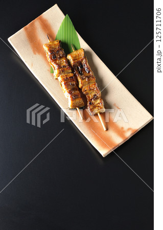 鰻の串焼きを黒背景で撮影 鰻の串焼きを黒背景で撮影 125711706