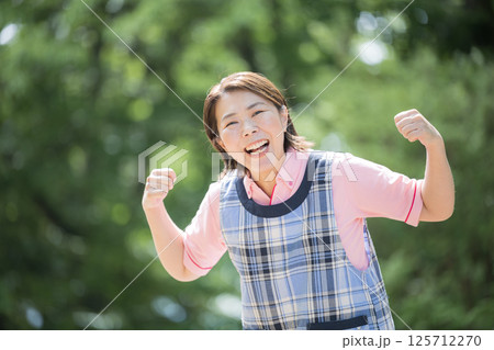 ベテラン介護士や保育士のイメージ笑顔でガッツポーズ40代の女性 ベテラン介護士や保育士のイメージ笑顔でガッツポーズ40代の女性 125712270