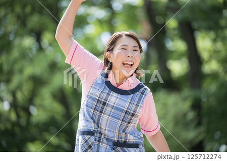 ベテラン介護士や保育士のイメージ笑顔でガッツポーズ40代の女性 125712274