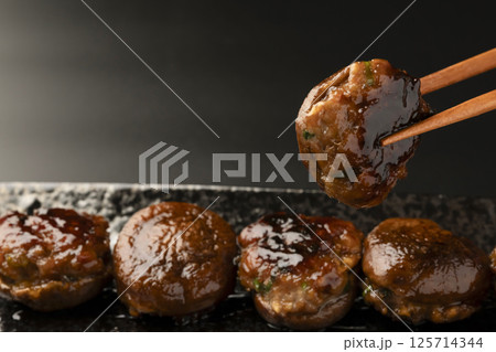 椎茸の肉詰めを橋で持ち上げる 椎茸の肉詰めを橋で持ち上げる 125714344