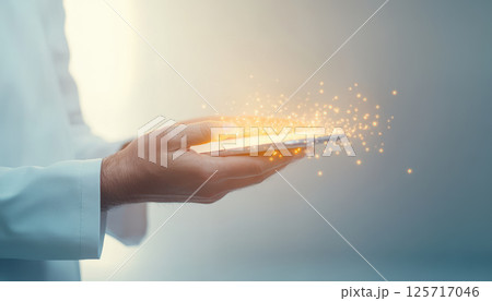 doctor hands hold smartphone emitting magical sparks, symbolizing innovation and technology in healthcare. image captures moment of wonder and advancement 125717046