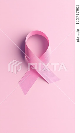 Serene presentation of a minimalist pink ribbon on a soft pink background with subtle accents. Minimalist design concept 125717903