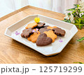 白いお皿にのった手作りクッキーと花（斜め） 125719299