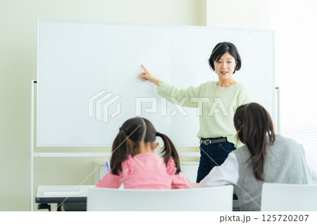 教室で授業をする教員と子供たち 125720207