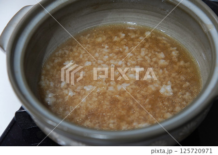 鍋の残り汁で雑炊を作る様子 125720971