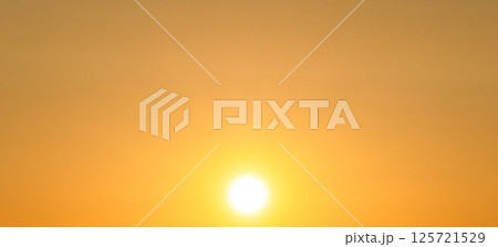 夕方に黄金色に染まる太陽と空と不思議な空間 125721529