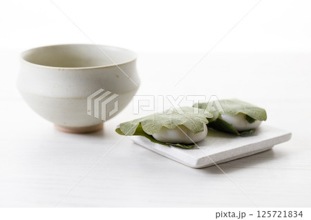 Kashiwa mochi and Cup of fresh matcha tea. Japanese sweet from mochi or rice cake and sweet red bean paste filling surrounded with Kashiwa or Oak leaf . 125721834