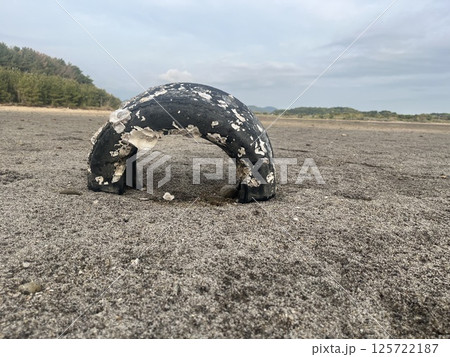 砂浜に埋まったタイヤ 125722187