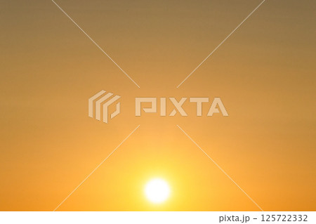 夕方の茜色に染まった空と太陽 125722332