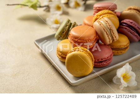 Macarons cookies in a plate, french macarons. Spring flowers on background 125722489
