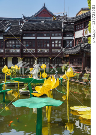 Shanghai, China - 1 April 2025: Serene pond in Yuyuan Garden with water lilies, golden fish, and a traditional statue. Historic Chinese architecture reflects in calm water. Peaceful cultural scene Shanghai, China - 1 April 2025: Serene pond in Yuyuan Garden with water lilies, golden fish, and a traditional statue. Historic Chinese architecture reflects in calm water. Peaceful cultural scene 125722583