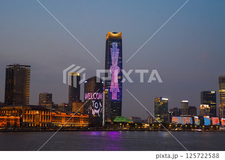 Shanghai, China - 1 April 2025: Night view of glowing Pudong skyline across the Huangpu River, illuminated skyscrapers reflecting on water 125722588