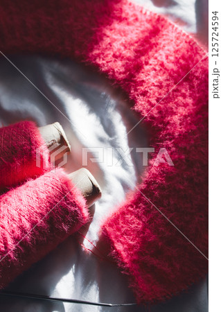 Bright pink knitting with knitting needles on white sheet. Soft pink knitwear with circle needles. Knitting pattern background. Knitting lifestyle. Cozy hobby. Warm knitwear. Craft product concept Bright pink knitting with knitting needles on white sheet. Soft pink knitwear with circle needles. Knitting pattern background. Knitting lifestyle. Cozy hobby. Warm knitwear. Craft product concept 125724594