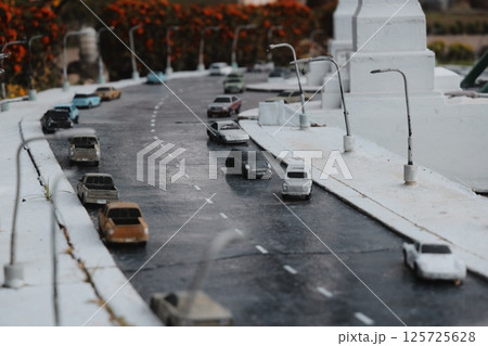 A miniature city street scene showcases vibrant cars and charming streetlights in art and design 125725628