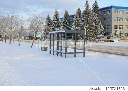 A serene winter scene shows a bus shelter in a snowy landscape, adorned with sparkling frost A serene winter scene shows a bus shelter in a snowy landscape, adorned with sparkling frost 125725768