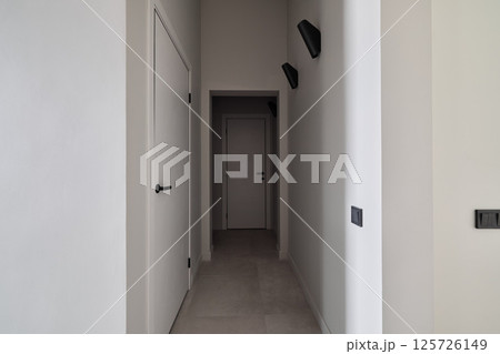 A minimalist hallway with modern lighting fixtures that enhance its aesthetic and functionality 125726149