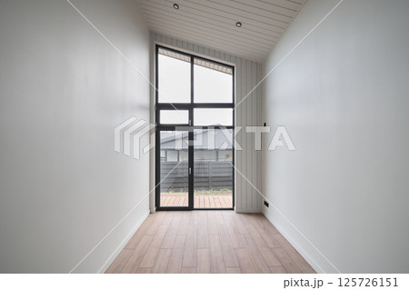 This is a Modern Minimalist Room that features a Large Window and a Beautiful Wooden Floor 125726151