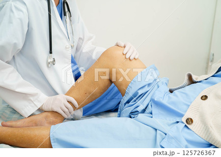 Doctor checking Asian elderly woman patient with scar knee replacement surgery in hospital. Doctor checking Asian elderly woman patient with scar knee replacement surgery in hospital. 125726367